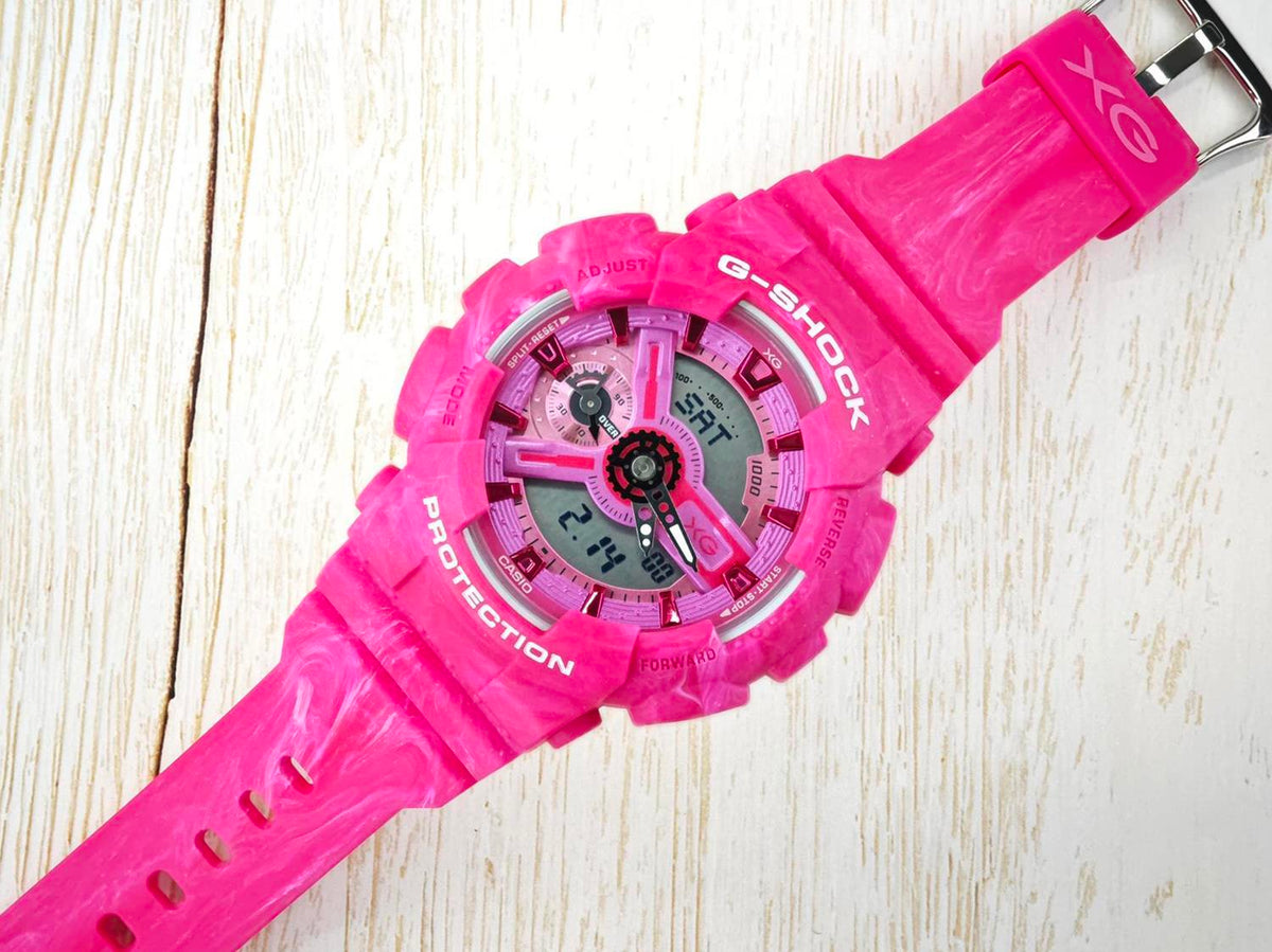 XG GMA-S110XG pink marbled Casio watch laid diagonally